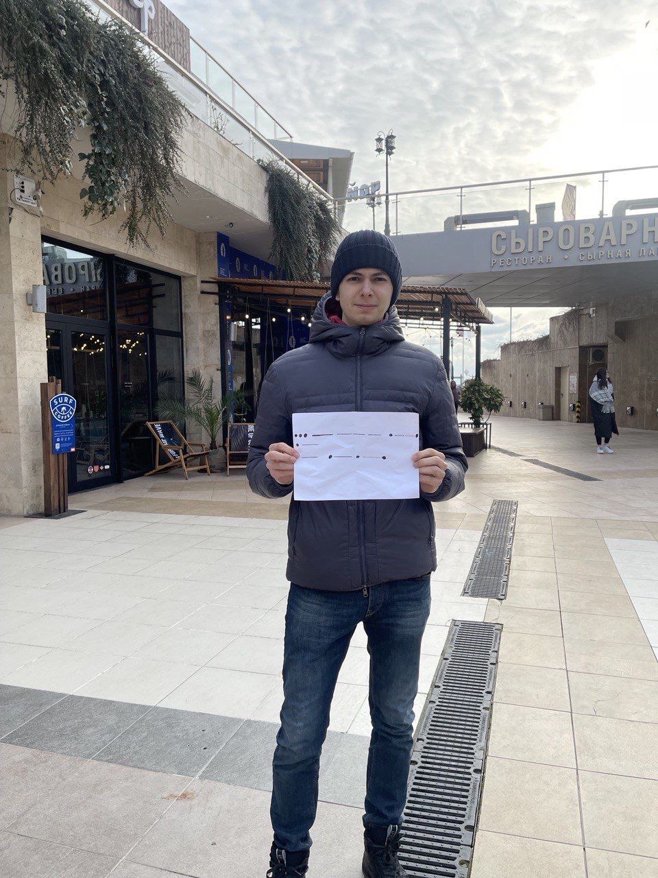 Тимур стоит на улице Сочи с плакатом протеста